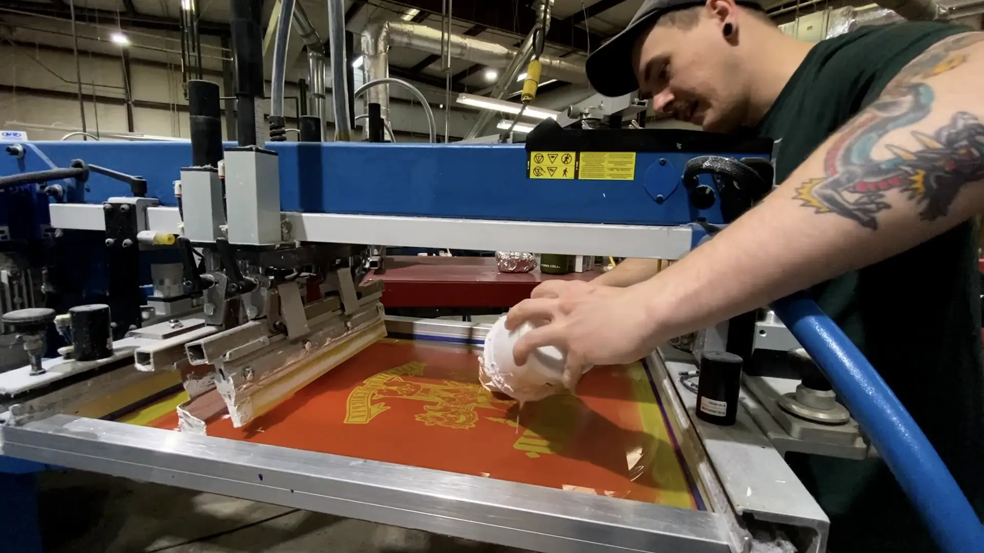 Production team member adding ink to a screen